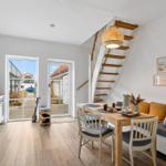 Kitchen, dining area, and staircase to bedroom with window to street.