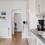 Kitchen with countertop, coffee maker, and passageway to living area.
