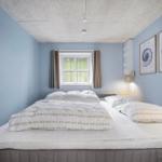 Schlafzimmer mit Bett, Fenster und Wandbildern