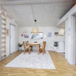 Essbereich mit Tisch, Stühlen und Deckenlampe. Holzfußboden und helle Wände.