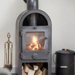 Holzofen mit brennendem Feuer und Holzstapel darunter.