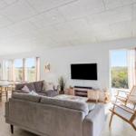 Wohn- und Essbereich mit Sofa, TV und Blick auf die Landschaft.