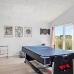 Raum mit Tischtennisplatte, Dart und Foosball. Fenster mit Blick auf Feld.