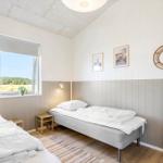 Schlafzimmer mit zwei Betten, Fenster und Wanddekoration.