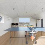 Room with ping pong table, pool table, and window with view.