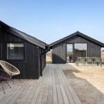 Two black wooden houses with terrace and outdoor seating.