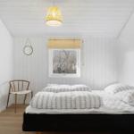 Bedroom with bed, chair, and window. Ceiling white, floor light brown.