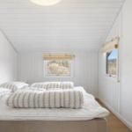 Bedroom with bed, windows, and wall art.