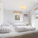 Bedroom with bed, windows, and ceiling lamp.