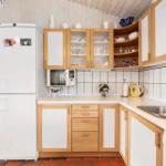 Kitchen with refrigerator, microwave, sink, and wooden cabinets.