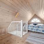 Bedroom with wooden walls, bed, seating, and window