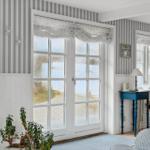 Room with striped wallpaper, white windows, and blue table.