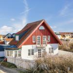 Red wooden house with white facade and dormer windows