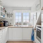 Kitchen with white cabinets, window, and kitchen appliances.
