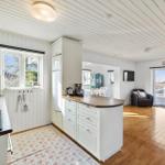 Kitchen with island, dining area, and bedroom in the background.