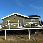 Green house with terrace and garden under blue sky