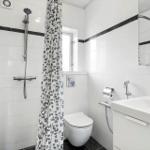 Bathroom with shower, toilet, and sink.