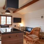 Küche mit Essbereich, Sofa und Fernseher in Holzhaus.