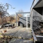 Terrasse mit Grill, Tisch und Stühlen. Durchgang zur Loungezone.