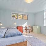 Schlafzimmer mit Doppelbett, Fenstern und Holzboden.