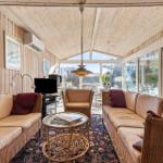 Wohnraum mit Holzwand, Sofa, Tisch und Fenster zur Aussicht.