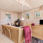 Wohnzimmer mit Holzwand, Kamin und Rattanmöbeln.