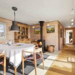 Esszimmer mit Holzwand, Esstisch, Kamin und Bildern an der Wand.