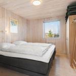 Schlafzimmer mit Holzwand, Bett, Kleiderschrank und Fenster mit Blick.