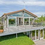Moderne Villa mit großem Balkon und Glasfassade. Terrasse mit Sitzgelegenheiten.