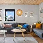 Wohnzimmer mit zwei Sofas, runden Tisch und Holzdecke.