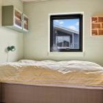 Schlafzimmer mit Bett, Fenster und Holzregal.