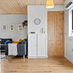 Wohnraum mit Holzboden, Sofa und Kücheninsel