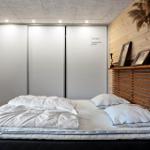 Schlafzimmer mit Bett, Schrank und Holzwand