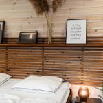 Schlafzimmer mit Holzwand, Bett und Dekoration.