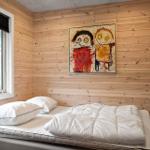 Schlafzimmer mit Holzwand, Bett, Fenster und Wandbild.