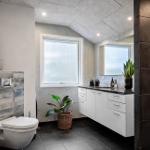 Badezimmer mit Toilette, Waschbecken und Pflanzen