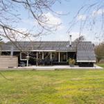 Moderne Villa mit Terrasse, Garten und Außensitzgelegenheiten.