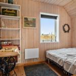 Schlafzimmer mit Holzwand, Bett, Schreibtisch und Fenster mit Blick.