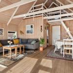 Wohn- und Essbereich mit Holzdecke, Sofa, Tisch und Stühlen.