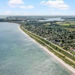 Ausblick auf Küstenort mit Strand und Wohnhäusern entlang des Wassers.
