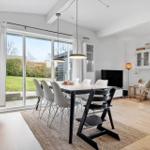 Moderne Esszimmer mit Tisch, Stühlen und Blick auf Garten.