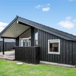 Moderne Holzhütte mit Terrasse und grünem Rasen. Fenster zeigen innere Räume.