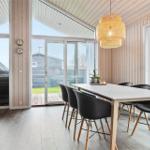 Essbereich mit Tisch, Stühlen und Glasfront zur Terrasse.