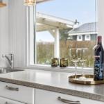 Küchenbereich mit Fensterblick, Weinflasche und Gläser auf Ablage