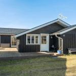 Wooden house with deck and garden. White windows and door.