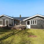 Wooden house with terrace and garden. White windows and door.