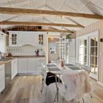 Kitchen with dining area, wooden beams, and glass doors to the outside.