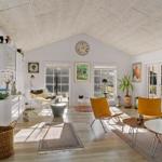 Living space with high ceiling, windows, and modern furniture.