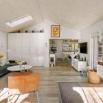 Living area with sofa, table, and kitchen area in the background.