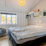 Bedroom with bed, window, and bookshelf on the wall.